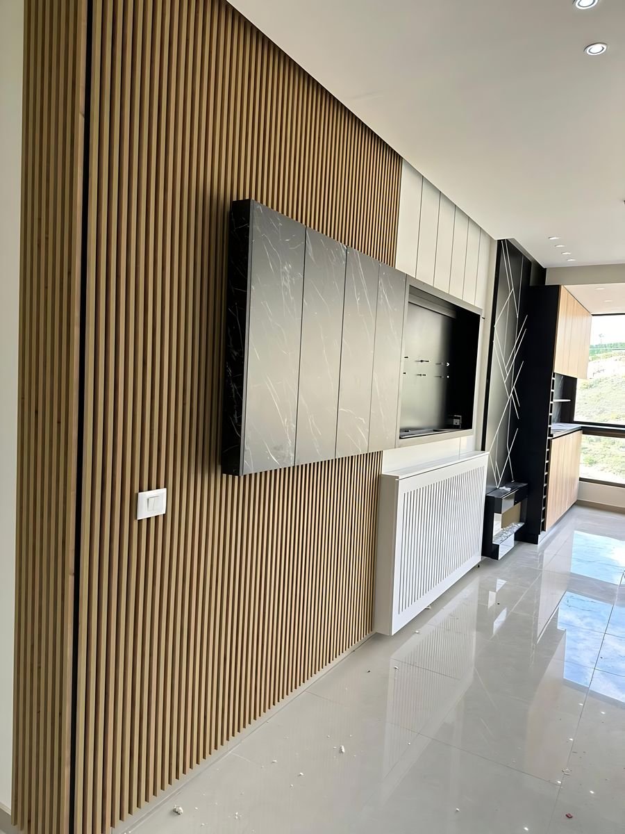 Full-height oak slat wall with a TV panel