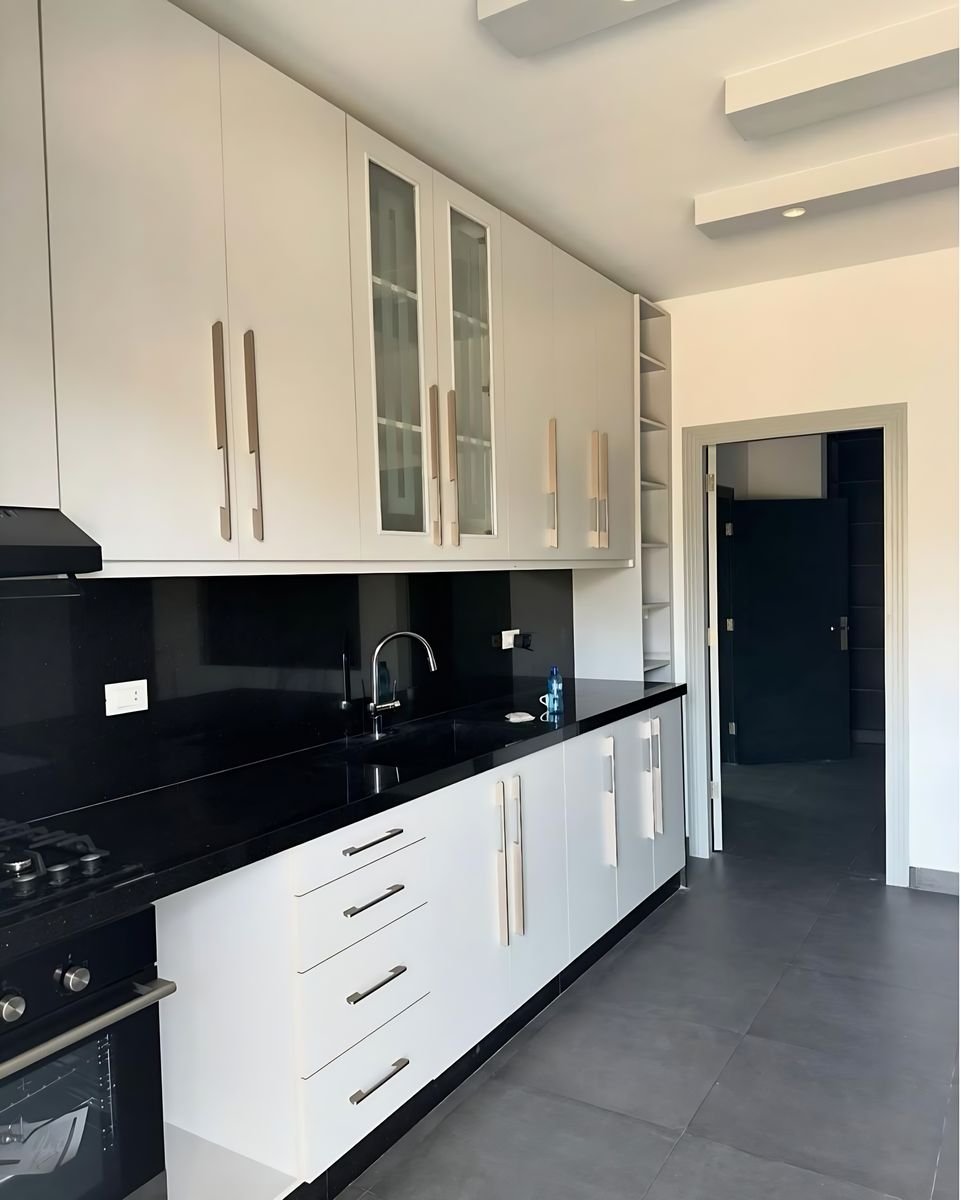 White kitchen with black worktop and splashback