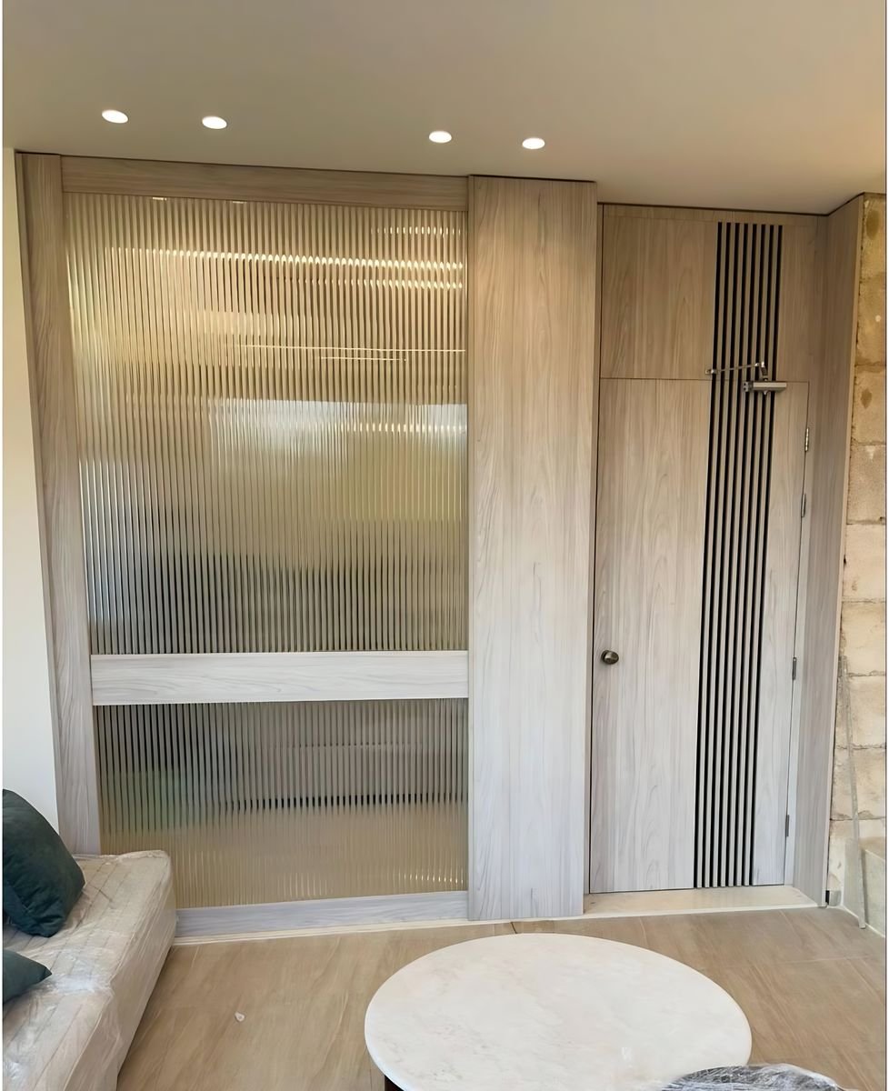 Reeded-glass sliding door in an oak frame